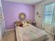 Comfortable bedroom featuring a decorative woven mirror and a plush bed with colorful throw pillows at 3329 Royal Tern Dr, Winter Haven, FL 33881