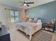 Tranquil bedroom featuring a comfortable bed, accent wall, and large window with natural light at 3329 Royal Tern Dr, Winter Haven, FL 33881