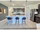 Inviting kitchen with an island, pendant lights, stainless steel appliances, and dark cabinetry at 3329 Royal Tern Dr, Winter Haven, FL 33881