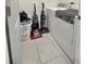 Practical laundry room equipped with a washer, dryer, cleaning supplies, and tiled flooring at 3329 Royal Tern Dr, Winter Haven, FL 33881