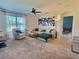 Bright living room featuring a comfortable sectional sofa, accent chair, and large window at 3329 Royal Tern Dr, Winter Haven, FL 33881
