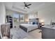 Cozy bedroom with tray ceiling, fan, and a comfortable bed, complemented by a desk and organized shelving at 338 Wooded Vine Dr, Winter Springs, FL 32708