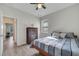 Light-filled bedroom featuring a striped bedspread, ceiling fan and a wooden dresser with natural-toned floors at 338 Wooded Vine Dr, Winter Springs, FL 32708