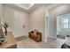 Bright foyer with light floors, stylish mirror, decorative table, and a wooden bench with storage near the front door at 338 Wooded Vine Dr, Winter Springs, FL 32708