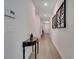 Hallway with light wood-look floors, decorated with wall art and a decorative table leading to the front door at 338 Wooded Vine Dr, Winter Springs, FL 32708
