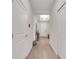 Hallway with light wood-look floors, leading to the front door, complemented by neutral walls and ceiling lighting at 338 Wooded Vine Dr, Winter Springs, FL 32708