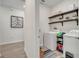 Bright laundry room with modern appliances, shelving, and storage, adjacent to a hallway with neutral-toned walls at 338 Wooded Vine Dr, Winter Springs, FL 32708