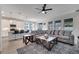 Open-concept living room with a large sectional sofa, modern rug, and bright kitchen with bar seating at 338 Wooded Vine Dr, Winter Springs, FL 32708