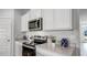 Modern kitchen with stainless steel appliances, white cabinets, and sleek countertops, ready for culinary adventures at 3715 Bluethread Way, Poinciana, FL 34759
