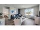 Stylish living room with hardwood floors, a comfortable blue sofa, and large windows offering natural light at 3715 Bluethread Way, Poinciana, FL 34759