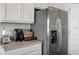 Gourmet kitchen featuring stainless steel refrigerator with white shaker cabinets and quartz countertops at 3719 Bluethread Way, Poinciana, FL 34759