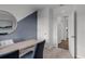 Well-lit office area showcasing a modern design with neutral carpet, and blue accent wall with large round mirror at 3719 Bluethread Way, Poinciana, FL 34759