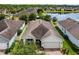 Aerial view of a single-story home with a well-maintained roof and landscaping near a serene lake at 4051 Prairie Reserve Blvd, Orlando, FL 32824