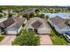Aerial view of a home with a neatly manicured lawn, brick driveway, and serene lake in the background at 4051 Prairie Reserve Blvd, Orlando, FL 32824