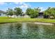 A tranquil pond view from the backyard, complemented by lush greenery and a charming fence at 4051 Prairie Reserve Blvd, Orlando, FL 32824