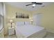 Cozy bedroom with a ceiling fan, soft lighting, and a comfortable bed with cityscape art at 4051 Prairie Reserve Blvd, Orlando, FL 32824