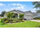 Inviting single-story home featuring a well-maintained lawn, mature landscaping, and a brick driveway at 4051 Prairie Reserve Blvd, Orlando, FL 32824