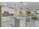 Open kitchen featuring white cabinets, a center island, and stainless steel appliances at 4051 Prairie Reserve Blvd, Orlando, FL 32824