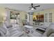 Bright living room features a ceiling fan, modern furniture, and access to the outdoor patio at 4051 Prairie Reserve Blvd, Orlando, FL 32824