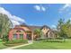 Beautiful clubhouse exterior with brick and siding, lush landscaping, and a well-manicured green lawn at 485 Forestway Cir # 108, Altamonte Springs, FL 32701