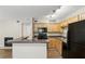 Well-lit kitchen with breakfast bar, dark countertops, and black appliances at 485 Forestway Cir # 108, Altamonte Springs, FL 32701