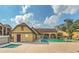 Outdoor pool area with brick paver decking, hot tub and community building under a bright, partly cloudy sky at 485 Forestway Cir # 108, Altamonte Springs, FL 32701