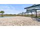 Community pool features shade structures, lounge seating and palm trees surrounded by a black fence at 4977 Kaia Ave, Winter Haven, FL 33884