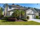 Well-maintained home exterior featuring lush lawn, decorative landscaping, and an attached two-car garage in a Gathering-friendly community at 5007 Bellthorn Dr, Orlando, FL 32837