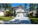 Home featuring a manicured lawn, bushes, and a two-car garage at 5007 Bellthorn Dr, Orlando, FL 32837