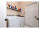 Functional laundry room with washer, dryer, shelving, and door to the exterior at 5007 Bellthorn Dr, Orlando, FL 32837