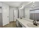 Bright bathroom featuring double sinks, quartz countertops and a shower with tile accents at 520 Starstone Dr, Lake Mary, FL 32746
