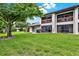 Backyard view featuring screened patios and lush green lawn on a sunny day at 600 Northern Way # 103, Winter Springs, FL 32708