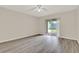 Bright bedroom featuring wood-look flooring and sliding door access to the backyard at 600 Northern Way # 103, Winter Springs, FL 32708