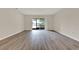 Open living room featuring wood-look floors and a sliding glass door to the outside at 600 Northern Way # 103, Winter Springs, FL 32708