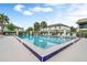 Triangle-shaped community pool with lounge chairs and green landscaping at 600 Northern Way # 103, Winter Springs, FL 32708