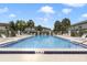 Relaxing pool area with lounge chairs, palm trees, and a clear blue sky at 600 Northern Way # 103, Winter Springs, FL 32708