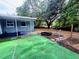 Expansive backyard featuring artificial turf, privacy fence, and a tranquil outdoor setting with mature trees at 605 Pleasantdale Dr, Wildwood, FL 34785
