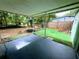 Covered patio with a backyard featuring artificial turf, partially fenced, and space for outdoor enjoyment at 605 Pleasantdale Dr, Wildwood, FL 34785