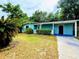 Inviting single-story house with a well-manicured lawn, bright exterior paint, and a cozy carport at 605 Pleasantdale Dr, Wildwood, FL 34785