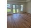 Cozy bedroom filled with natural light and featuring hardwood floors and glass doors to the backyard at 6125 Village Edge Pl, Sanford, FL 32771