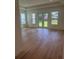 Bright bedroom with tray ceiling, hardwood floors, and glass doors leading to the lush backyard at 6125 Village Edge Pl, Sanford, FL 32771