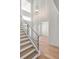 Elegant foyer showcasing a modern staircase, glass railings, wood floors, and decorative wall paneling at 6125 Village Edge Pl, Sanford, FL 32771