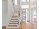 Inviting foyer with hardwood floors, staircase with glass railings, and a modern front door at 6125 Village Edge Pl, Sanford, FL 32771