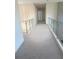Upstairs hallway featuring neutral carpet and glass railings at 6125 Village Edge Pl, Sanford, FL 32771