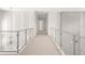 Upstairs hallway with modern glass railings and decorative wall trim at 6125 Village Edge Pl, Sanford, FL 32771