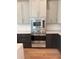 Modern kitchen features stainless steel appliances, light gray upper cabinets, and dark lower cabinets at 6125 Village Edge Pl, Sanford, FL 32771