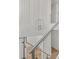 Modern staircase with glass railings, hardwood floors, and decorative wall accents, enhancing the home's aesthetic at 6125 Village Edge Pl, Sanford, FL 32771