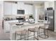 Modern kitchen with white cabinetry, stainless steel appliances, granite countertops, and bar seating at 674 Pennywort St, Lake Alfred, FL 33850