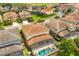 An aerial view shows this tile-roofed home's screened-in pool in a lush neighborhood at 7041 Oakwood St, Davenport, FL 33837