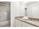 Bright bathroom featuring dual sinks, granite countertop, and shower-tub combination at 7041 Oakwood St, Davenport, FL 33837